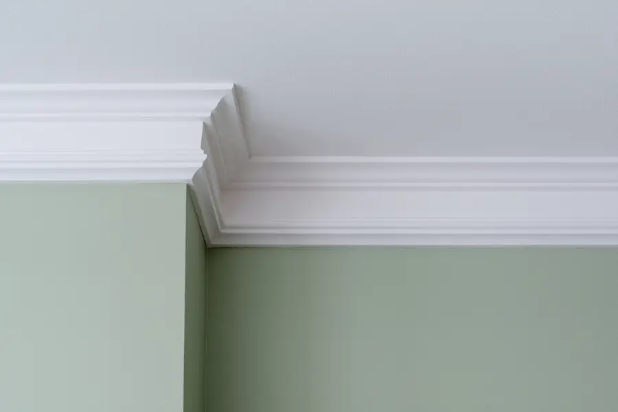 White decorative coving against green wall